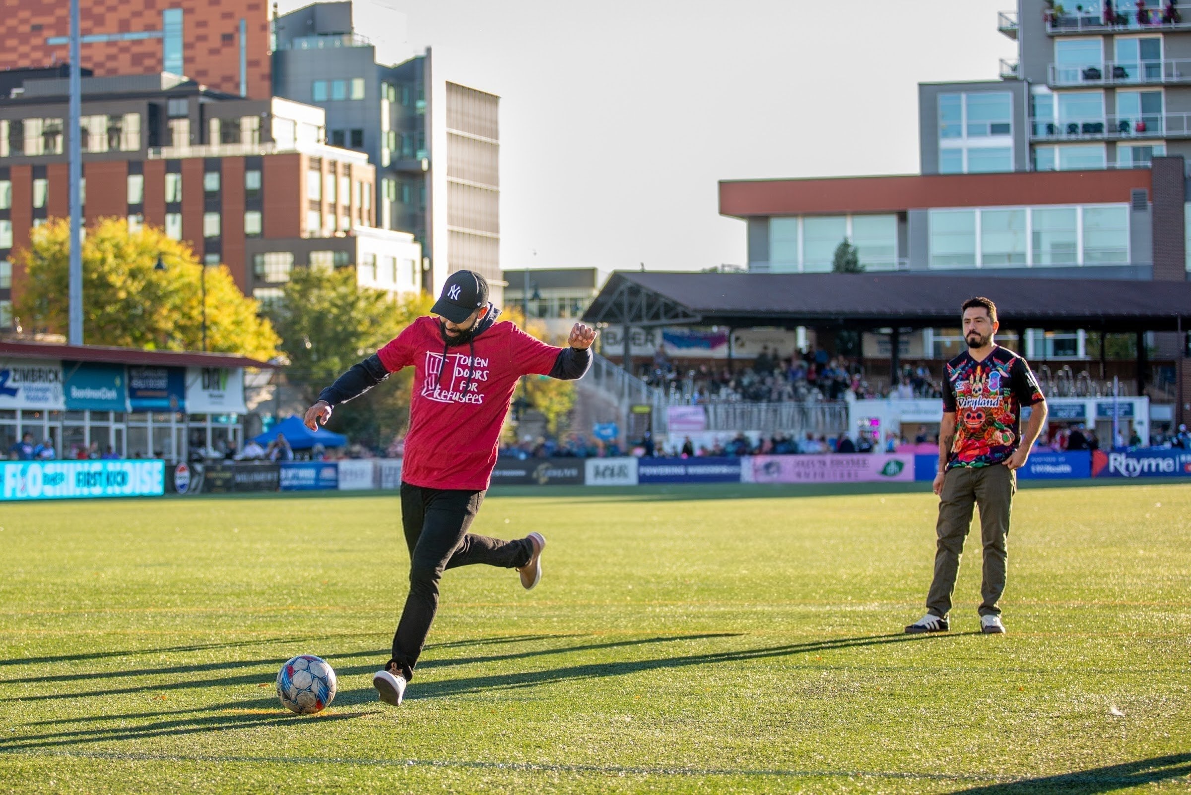 Person with an Open Doors shirt kicking the soccer ball at Breese Stevens Field